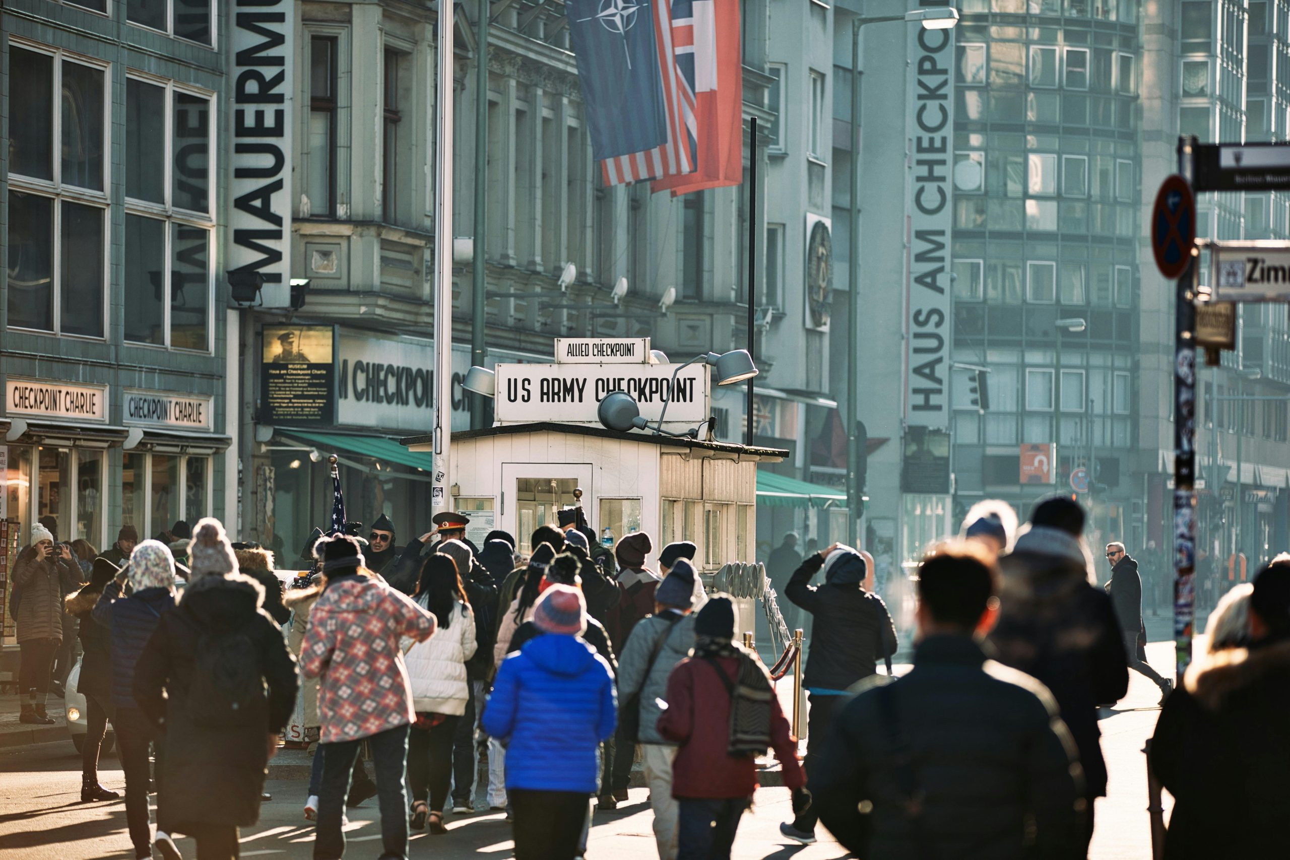 Crowd of tourists gathered at the historic Checkpoint Charlie in Berlin, Germany.