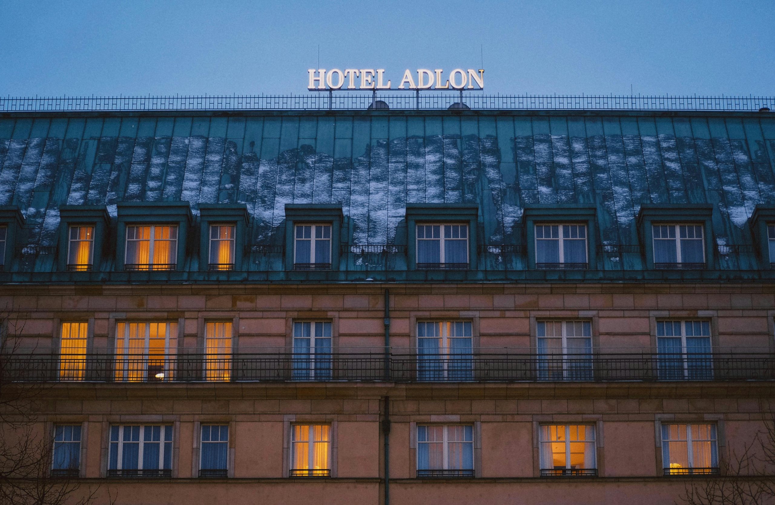 Evening view of Hotel Adlon in Berlin during winter, with illuminated windows.