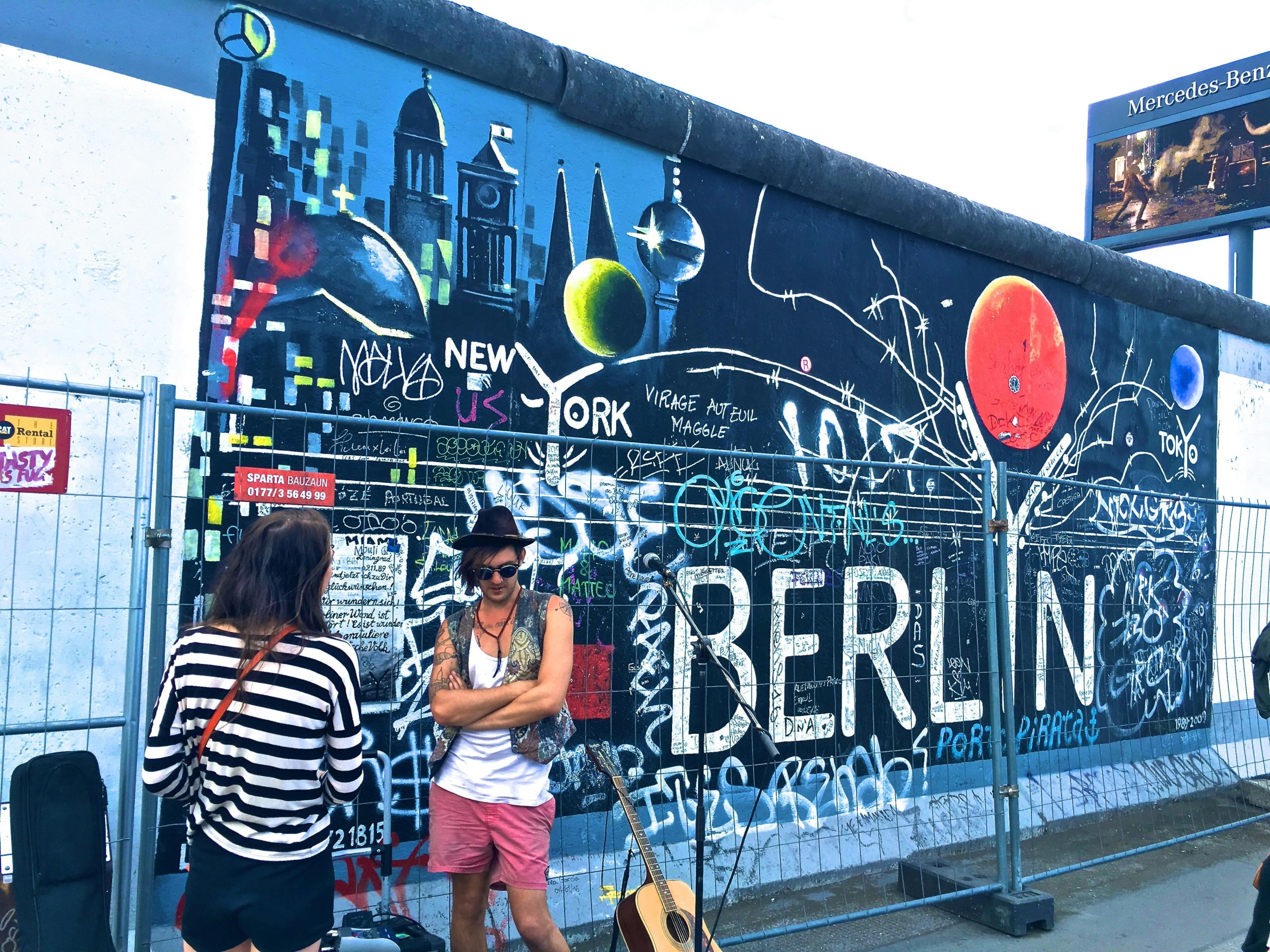 Vibrant street art on the Berlin Wall, captured amidst a lively urban atmosphere.